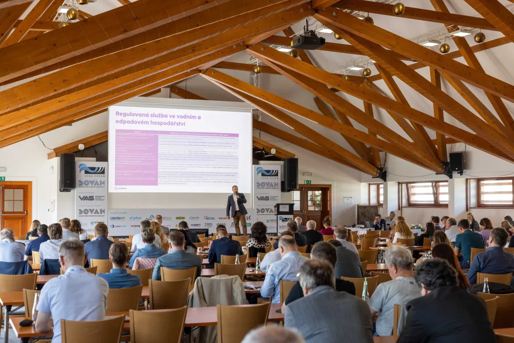 Plný sál naslouchá řečníkovi na konferenci
